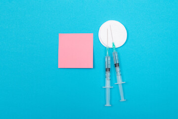 Vaccination, Immunology or Revaccination Concept - Two Medical Disposable Syringe Lying on Blue...