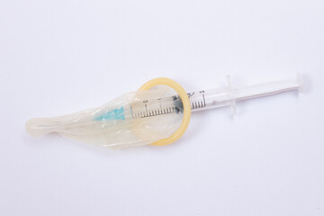 Save Vaccine and Anti Vaccination Concept - Syringe in a Condom Lay on White Table. Mistrust of...