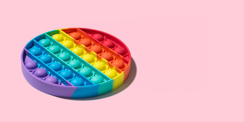 Round colored Pop it toy. New popular silicone anistress toy isolated on pink background. Minimalistic side view. Copy space