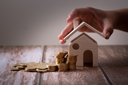 Save money concept, Property investment, house loan, reverse mortgage, gold coins money stack with on wooden table, saving money coins stack future for home with vintage  conceptual background.