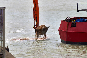 An excavator bucket lift sand from the seabed