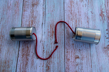 telefone de latas de conserva e cordel com o fio cortado. Conceito de incomunicabilidade.
