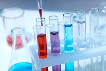 Closeup of laboratory glass tubes and pippete, colorful chemical liquids
