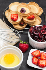 Yolk in bowl. Strawberries and sweet cherries in bowl