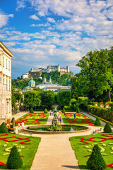 Fototapeta premium Beautiful view of famous Mirabell Gardens with the old historic Fortress Hohensalzburg in the background in Salzburg, Austria. Famous Mirabell Gardens with historic Fortress in Salzburg, Austria.