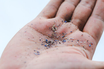Close up side shot of microplastics lay on people hand.Concept of water pollution and global...