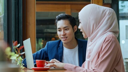 Fototapeta premium Smiley muslim teamwork use laptop in coffee shop