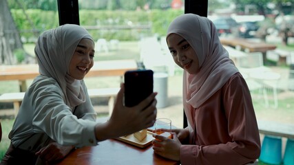 Pretty muslim woman and friend selfie with cake set