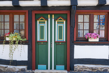 Detail of a typical half-timbered house in the Vogelsberg district with windows decorated with flowers 