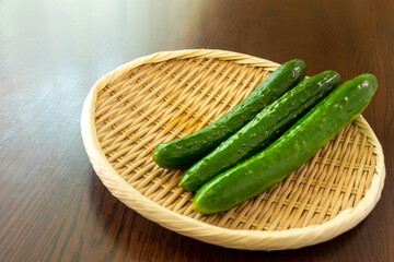 竹ザルにのせられた新鮮なキュウリ
