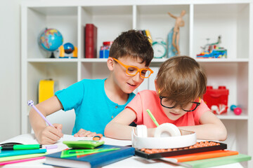 Pupil of primary school in class writing and reading. Home schooling and education at home. Boys at lesson in classroom.