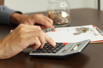 Obraz na płótnie Canvas Money management concept. Hand man use calculator to calculate the budgets.