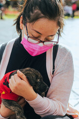 young girl with his puppy playing in a public square