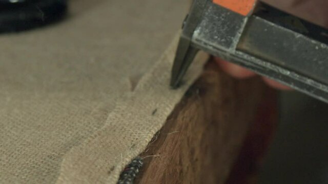 Man stapling on furniture upholstery, Kenilworth, Coventry, UK