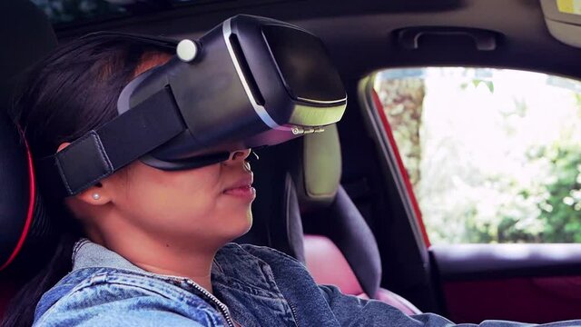 Woman driving simulation using virtual reality headset driving test in modern car. Smart technology concept.