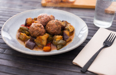 baked meatballs with stewed eggplant, zucchini, green peppers and tomatoes with haze in bowl