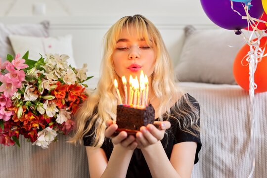 Birthday of female teenager, girl with birthday small cake with burning candles