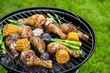 Chicken Drumstick Legs Grilling on Charcoal BBQ. Summer Picnic Food in Backyard Garden