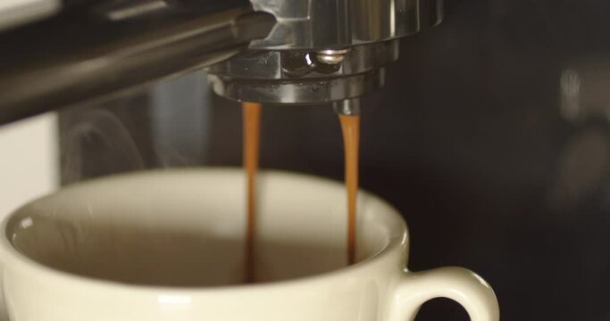 Delicious espresso coffeee being poured from a proffesional espresso machine 