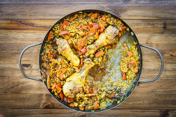 Typical Spanish food of Arroz con pollo or chicken paella in a paella pan that is missing a...