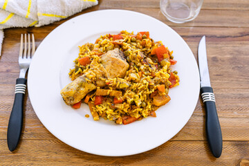 Typical Spanish food chicken rice or chicken paella. Plain close-up of a portion of chicken leg...