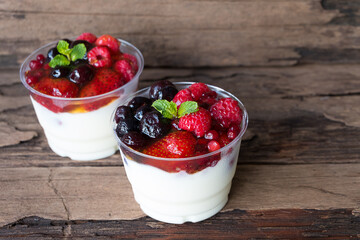 Fruit yogurt has strawberry raspberry blueberry canberry and honey greek white clean In bowl on a wooden background from top view.
