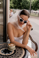 Woman in white suit and sunglasses in cafe, retro portrait