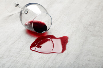 Wooden floor with overturned glass of red wine. Spilled wine on a wooden laminate parquet floor with moisture protection. 