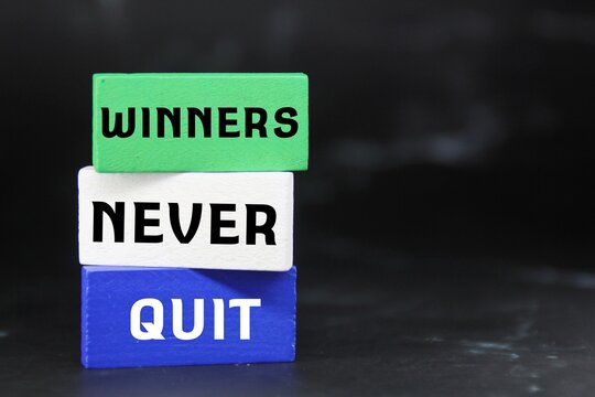colored cubes with the word winner never quit