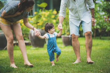 Fototapeta premium cute toddler little child family concept, baby learning to walk with father and mother to help care and holding hand, first step with childhood parent support, small love portrait little boy at home