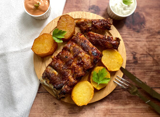 Grilled barbecue pork rib with fried potatoes, american sauce and garlic sauce. 