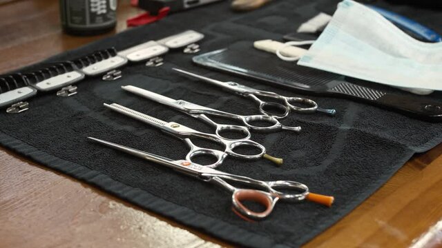 barber takes scissors from a full tool board slow motion