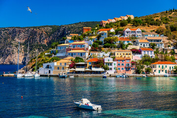 Fototapeta na wymiar Assos village in Kefalonia, Greece. Turquoise colored bay in Mediterranean sea with beautiful colorful houses in Assos village in Kefalonia, Greece, Ionian island, Cephalonia, Assos village.