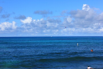 ハワイ・オワフ島・ホノルル、ワイキキビーチ。青い海、青い空、白い雲	。
