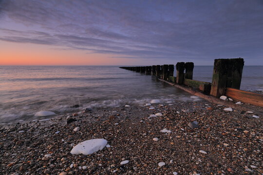 Groynes at the north beach in Bridlington at dawn, with motion blur of the waves.