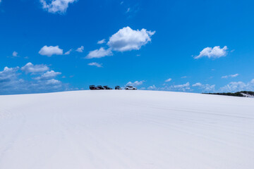 Cars parked on the paradisiacal dunes of the Brazilian desert
