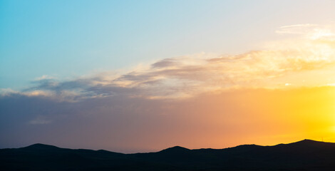 Obraz premium Bright golden sunset sky, and mountains silhouette. Nature sky mountains background.