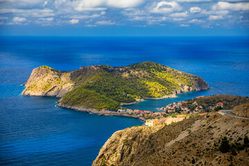 Assos village in Kefalonia, Greece. Turquoise colored bay in Mediterranean sea with beautiful colorful houses in Assos village in Kefalonia, Greece, Ionian island, Cephalonia, Assos village.