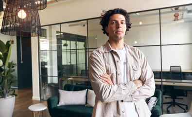 Fototapeta premium Portrait of young male business owner standing in rented open plan office space