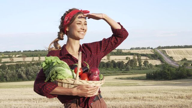 Woman farmer holding basket vegetable onion tomato salad cucumber standing farmland smiling Female agronomist specialist farming agribusiness 