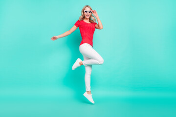 Full body profile side photo of young woman happy positive smile wear sunglass jump up isolated over turquoise color background