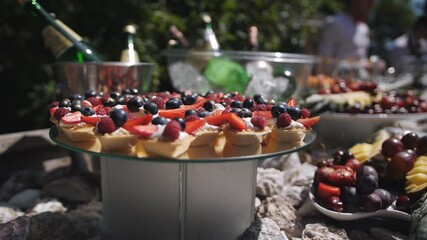 Buffet table at a summer holiday event. Cool drinks, fruits and dessert baskets on the buffet table at the festive event.