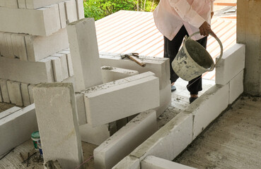 bricklayer use concrete bucket with liquid cement making coner beads in house site building