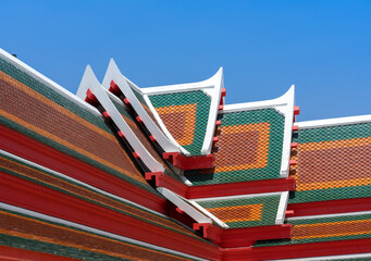 closeup old traditional Thai style roof of temple in Thailand, colorful tile roof with clear blue sky