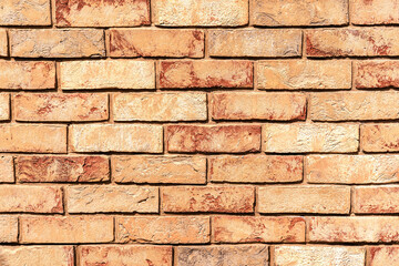 Fototapeta premium Sunlit weathered yellow and red brick wall. Brick texture for your design. Copy space.