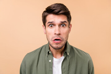 Photo of unhappy upset young man astonished stupor stare isolated on pastel beige color background