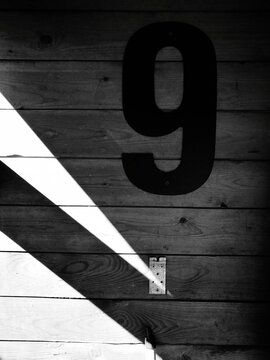 Close-up Of Plastic Digit 9 On Wooden Wall
