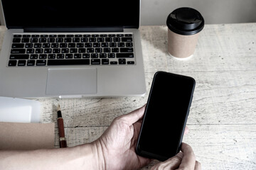 Businessman hand hold smartphone Workspace at home
