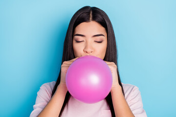 Portrait of attractive dreamy girl blowing air ball prepare celebration decor isolated over bright blue color background