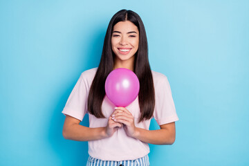 Photo of young attractive girl happy positive smile hold air balloon party event decoration isolated over blue color background